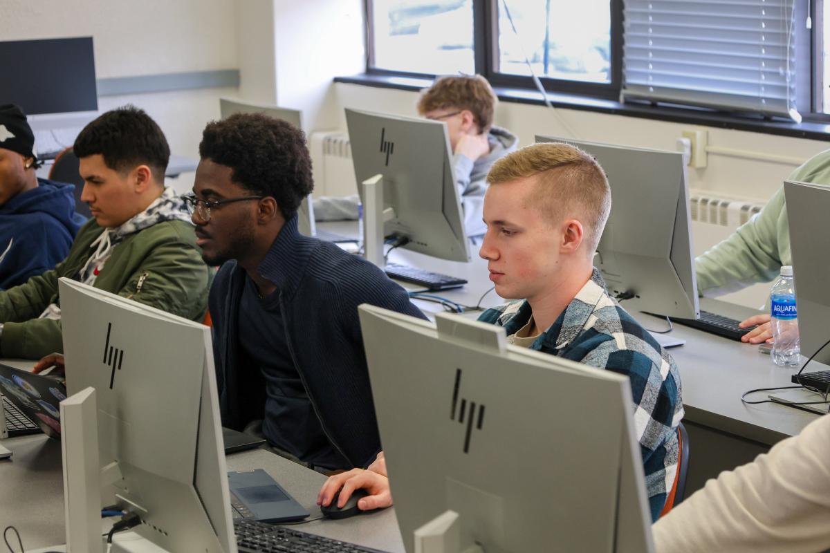 A student sitting in a podcast studio
