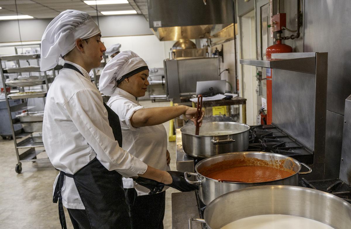 students work on sauce in the kitchen