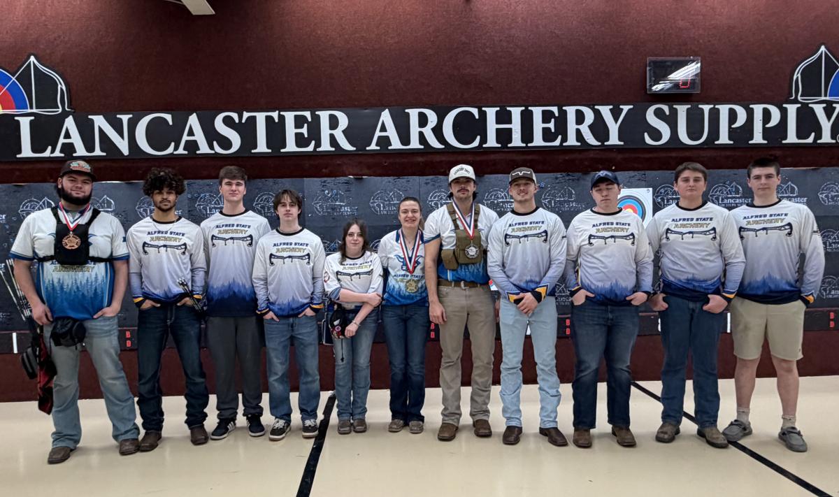 Archery team in front of a sign at Indoor Nationals