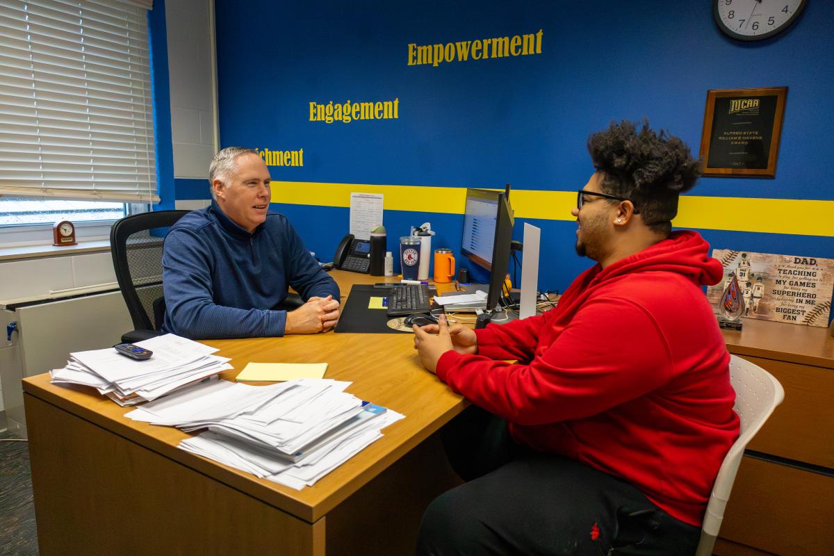 Advisor speaks with a student in his office