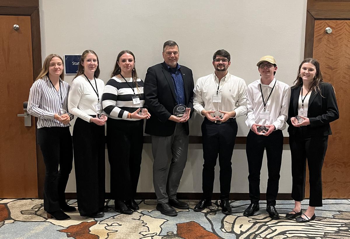students pose with their award following competition.
