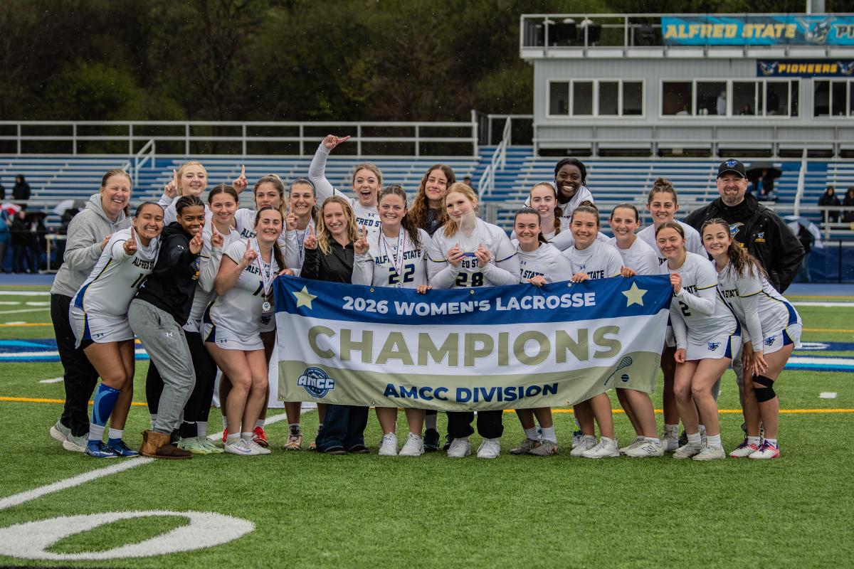 Alfred State women's lacrosse team with the championship banner
