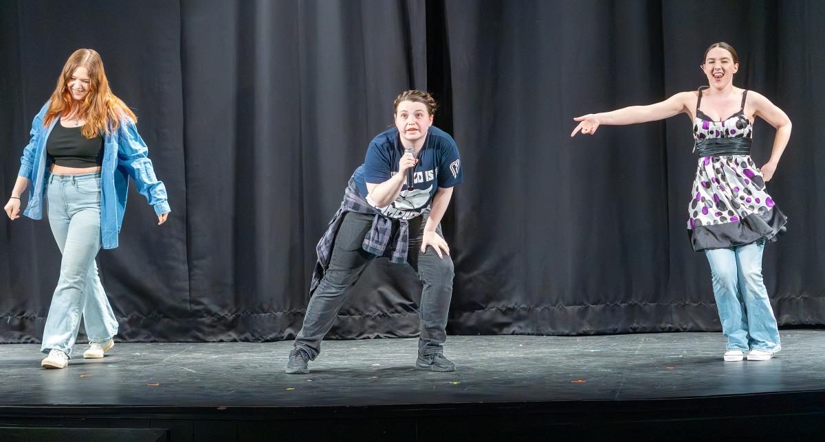 student performs a song on a stage