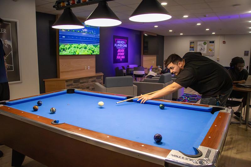 student shoots pool in the newest lounge on campus