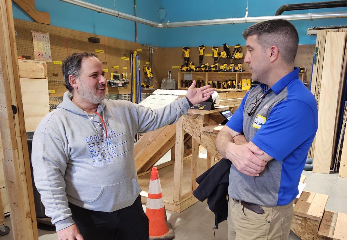 A teacher speaks with ASC Building Trades Chair Dan Helveston at an event at the Brooklyn STEAM Center