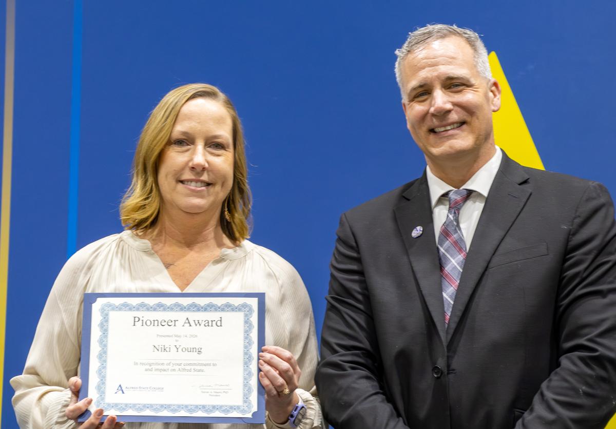 Niki Young shows her certificate while standing with Dr. Mauro.