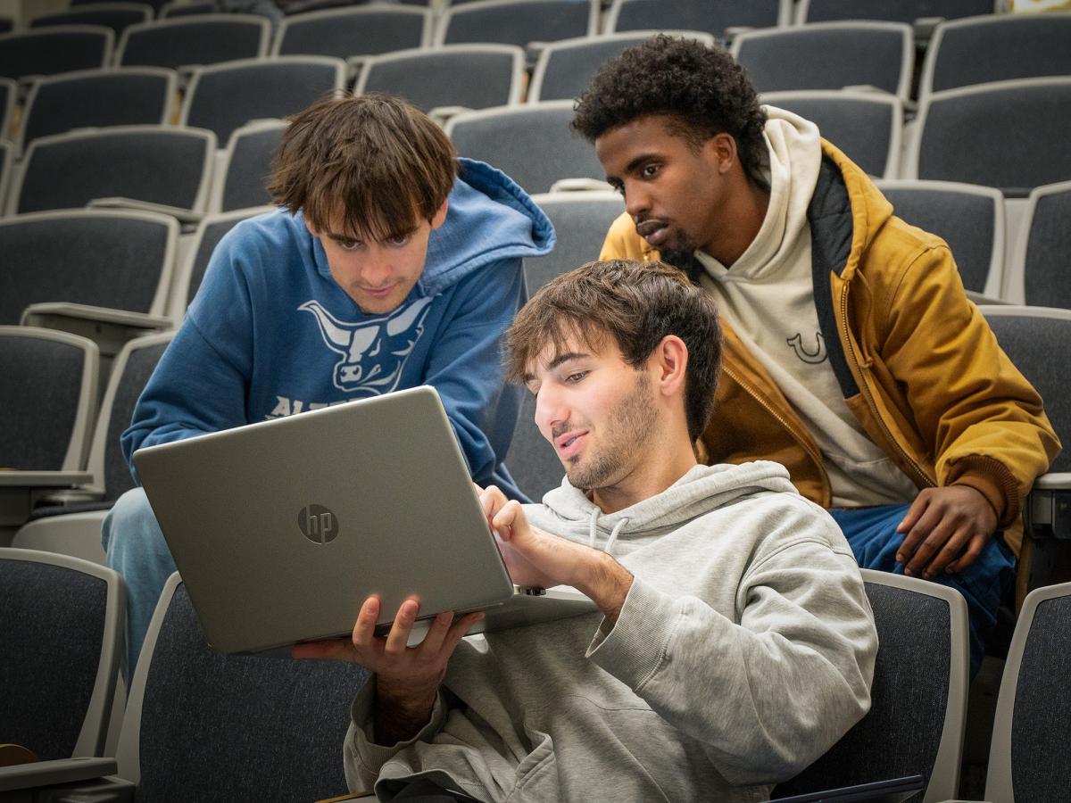 Students work together on a laptop