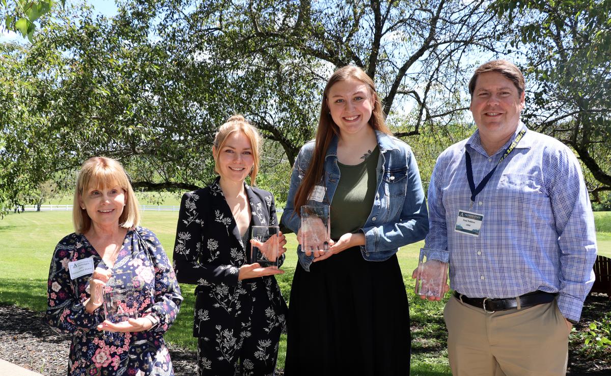 four individuals stand with the awards they were presented at the Alumni Brunch