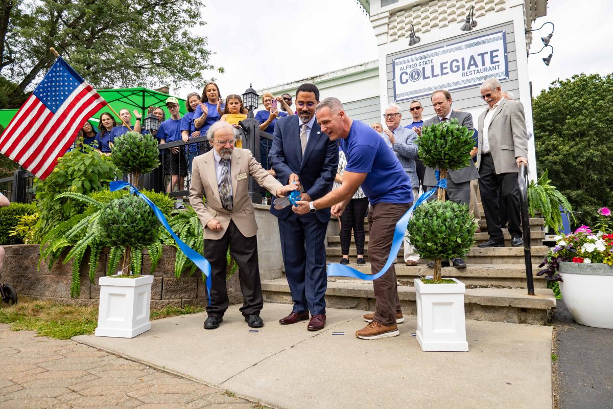 Dr. King participates in a ribbon cutting at the Collegiate during his last visit to Alfred State.