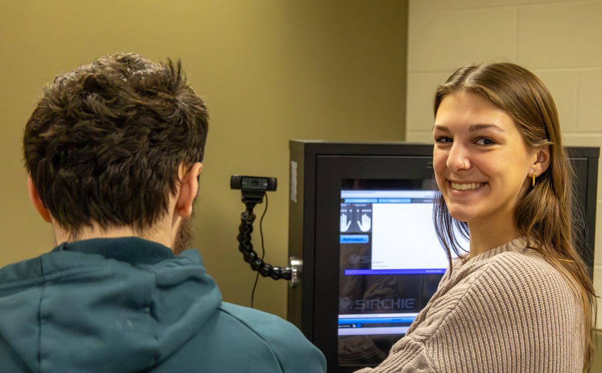 student takes finger prints of another student in a lab.
