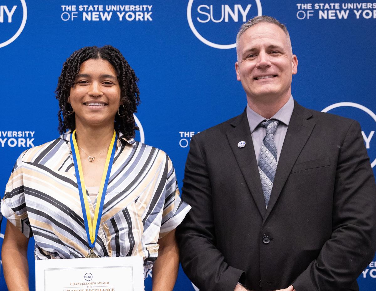 Student poses with award with Dr. Mauro
