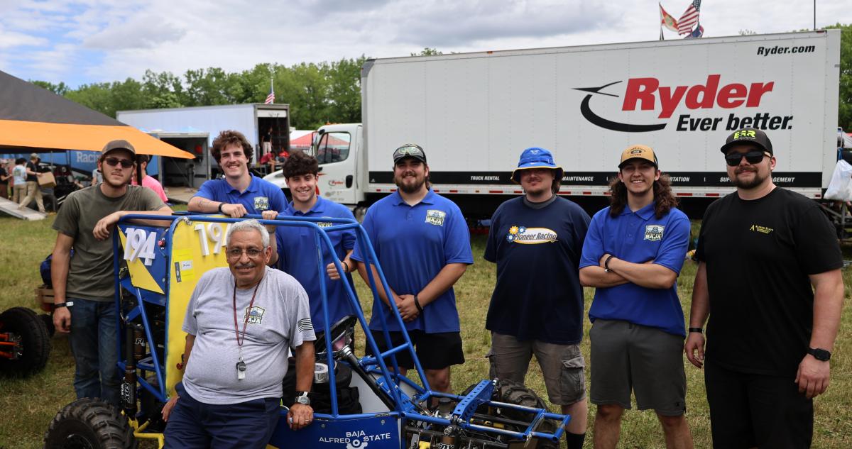 The Alfred State SAE Baja poses in front of their car