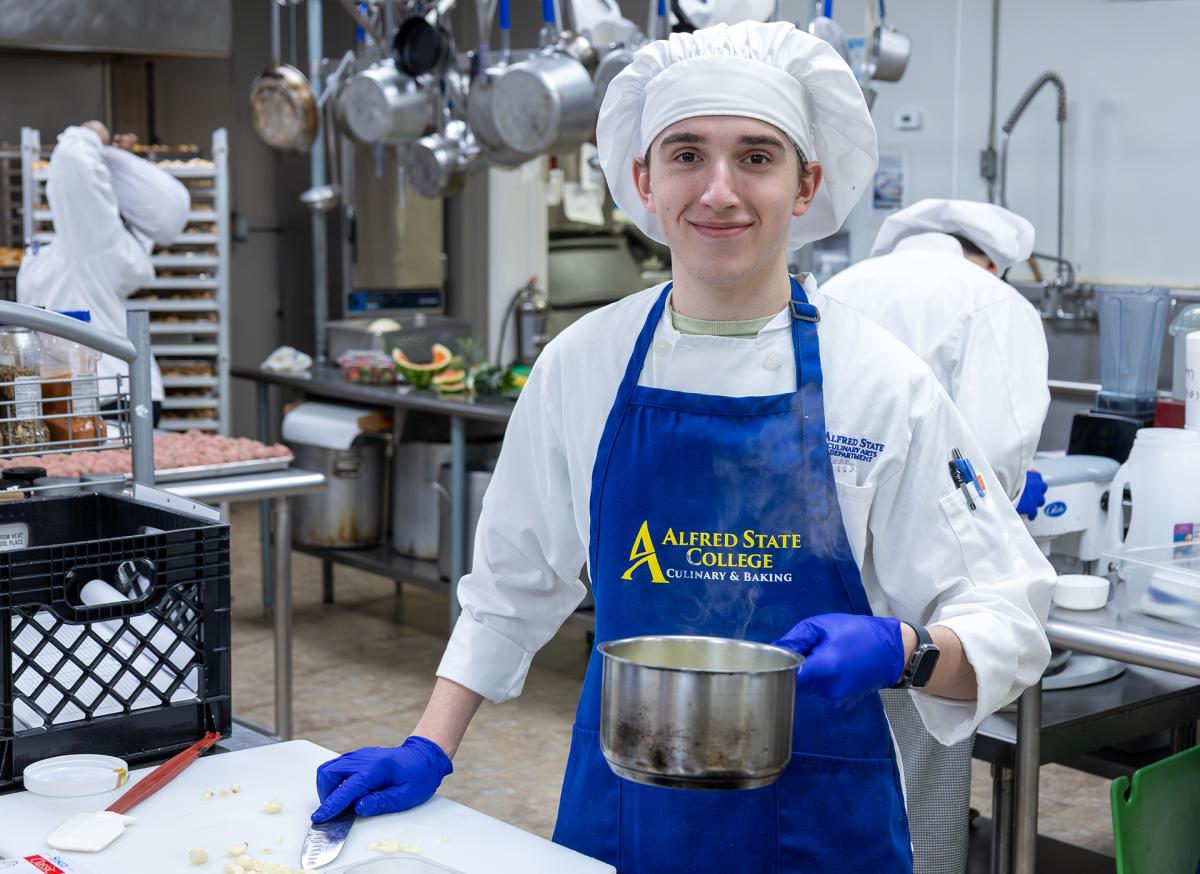 student shows off his work in the kitchen