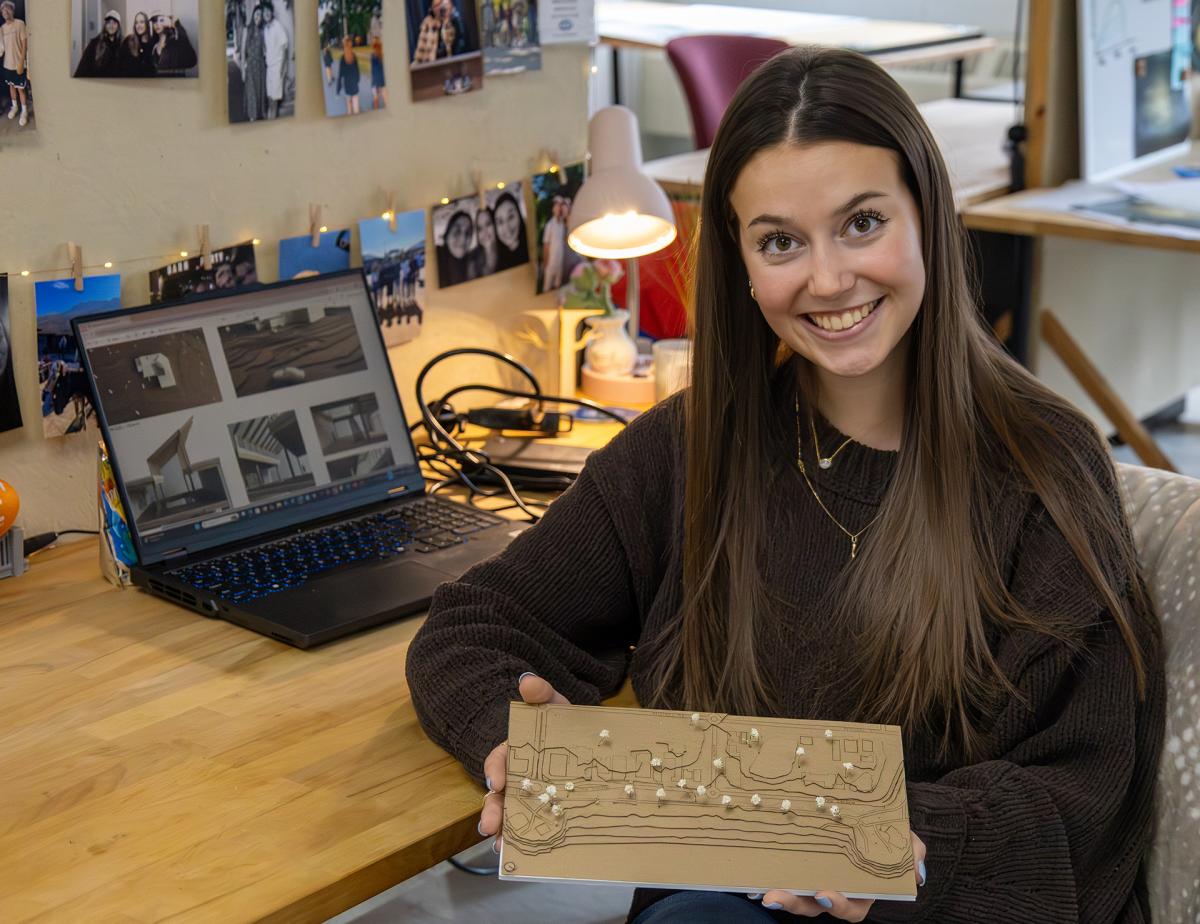 student shows off her model at her desk