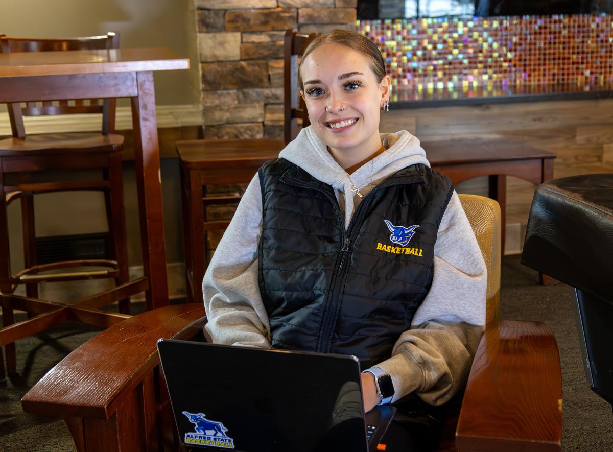 student sitting in a lounge with her laptop