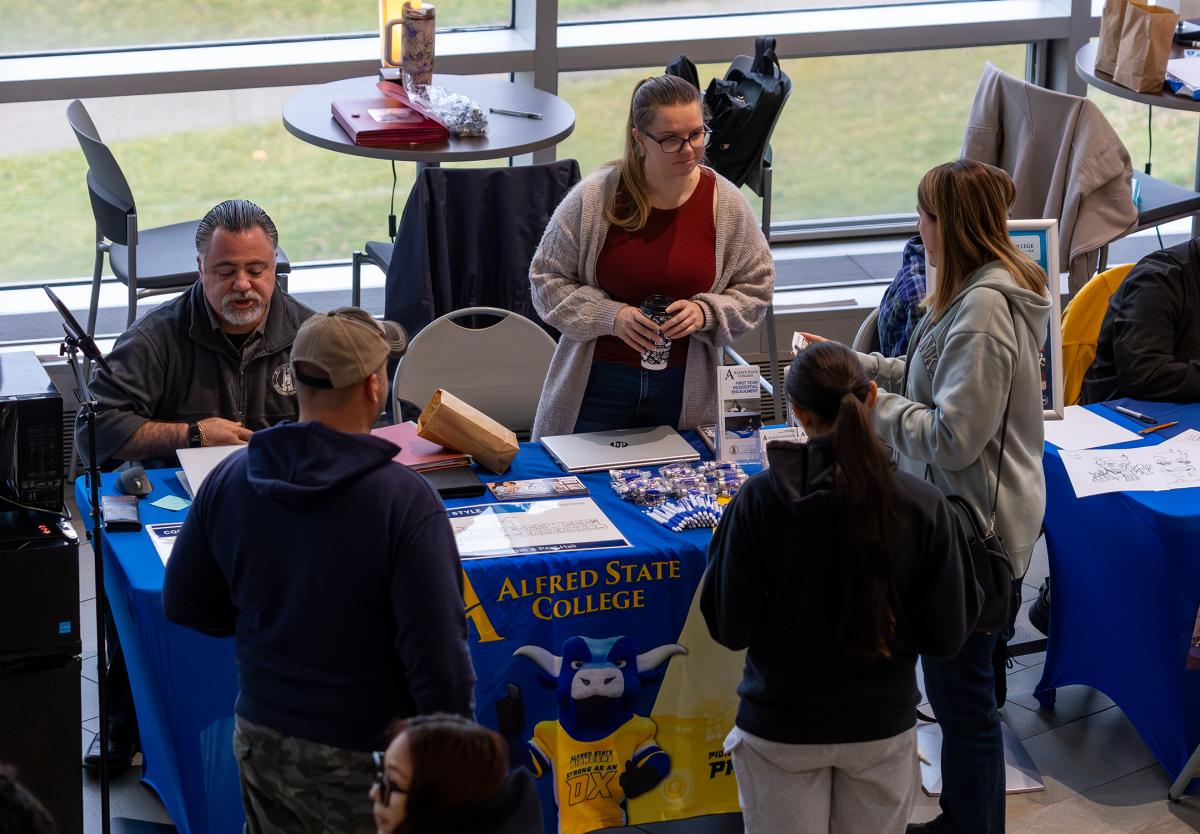 students talk to representatives from residence life at an open house