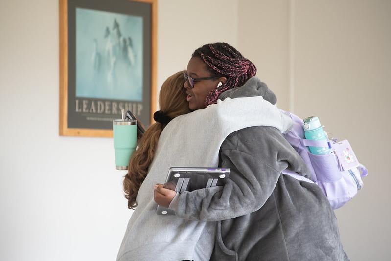 Students hug outside a classroom
