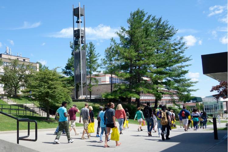 Students walk down the spine of campus by the Bell Tower.