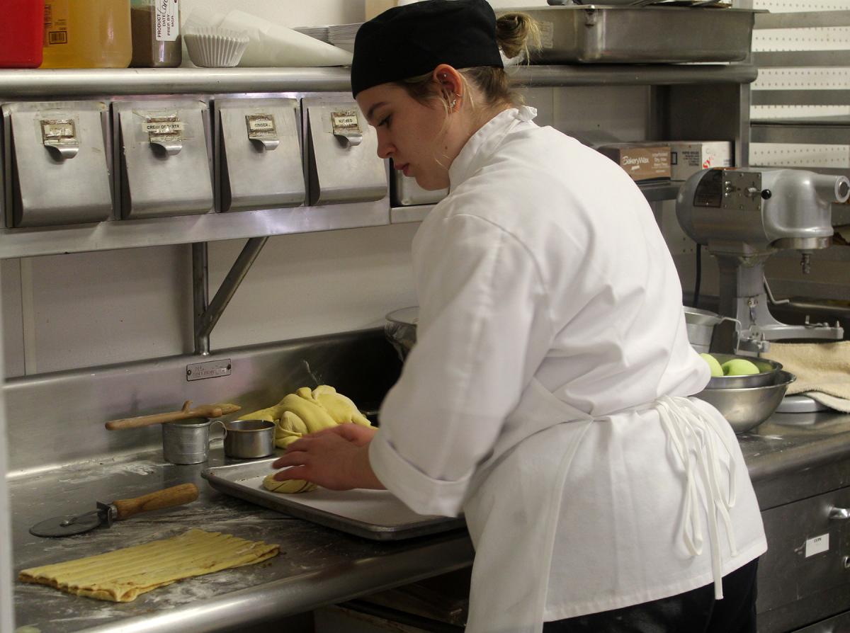 An Alfred State Culinary Arts student works in the kitchen.