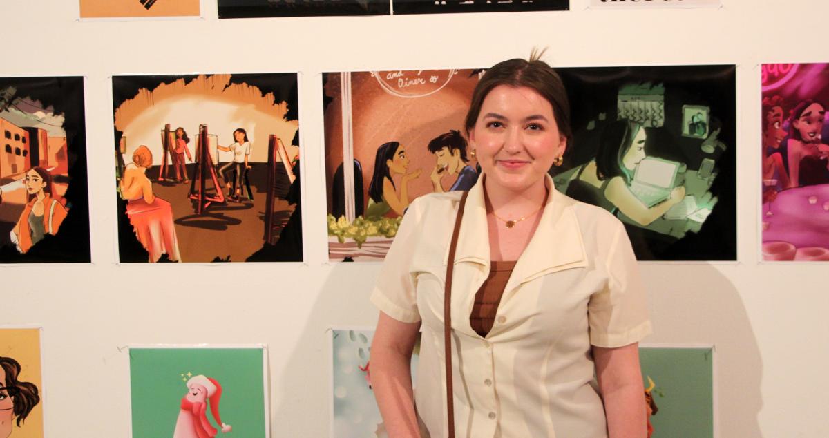 student stands in front of her artwork 