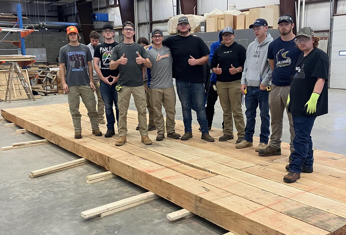 Building trades students stand on a bridge they constructed