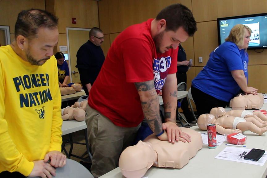 Alfred State Admissions Counselor Doug Tay (middle of picture) practice CPR compressions during a training session. 40 Alfred State employees attended the CPR/AED class held during the college Professional Development Week.