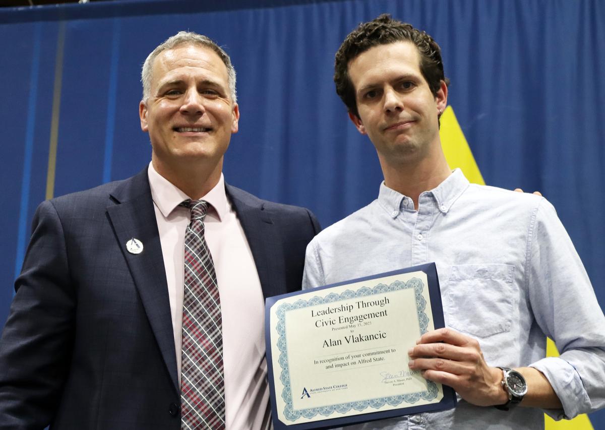 Alan Vlakancic accepts award from Dr. Mauro
