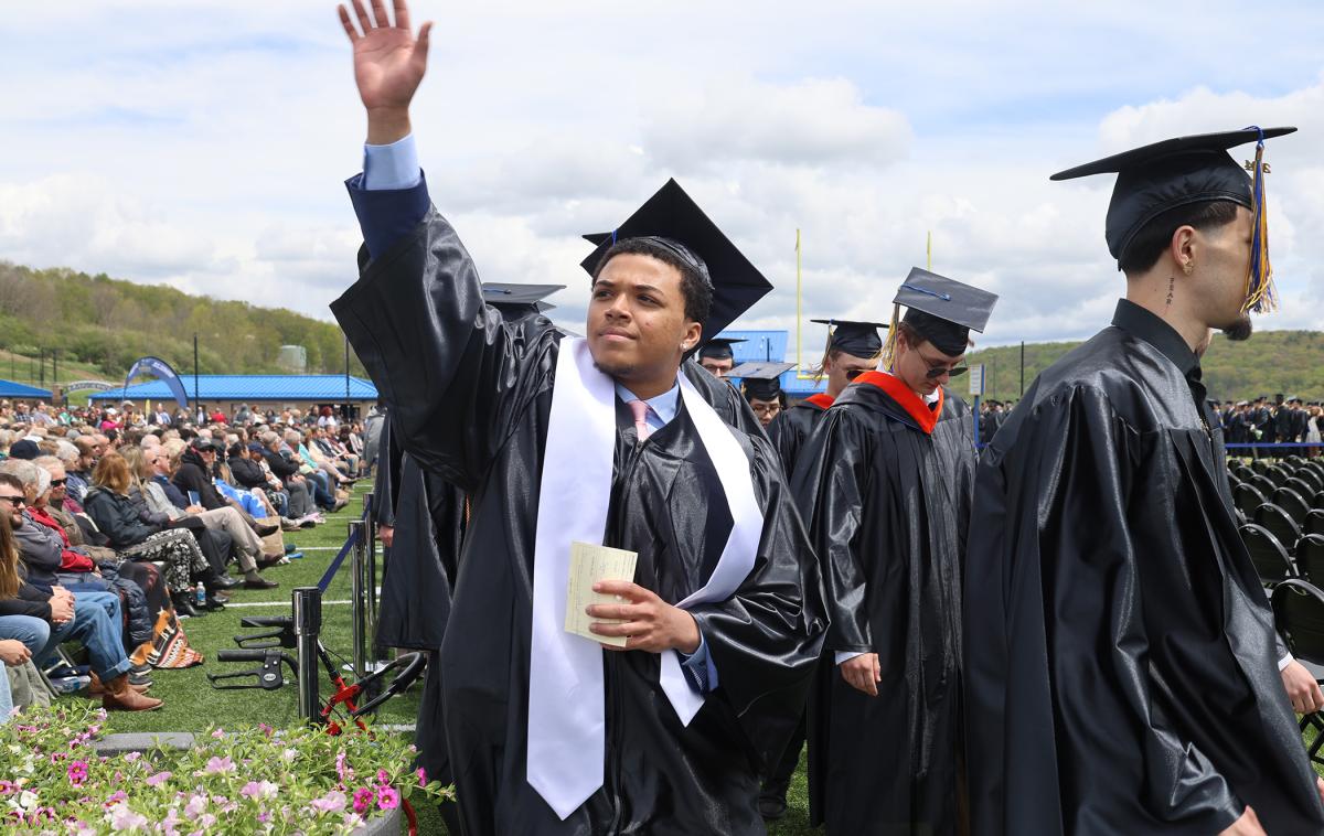An Alfred State student waves to family during Commencement