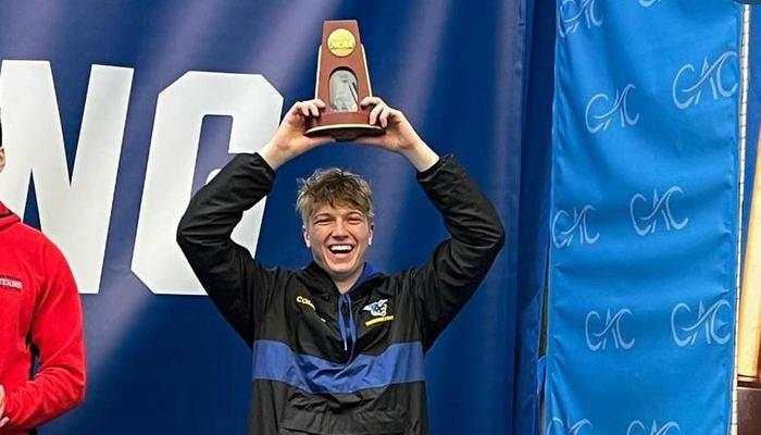 Conor Compton stands on the award stand after capturing 7th place at the NCAA Division III National Championship for performance on the 3m diving board.