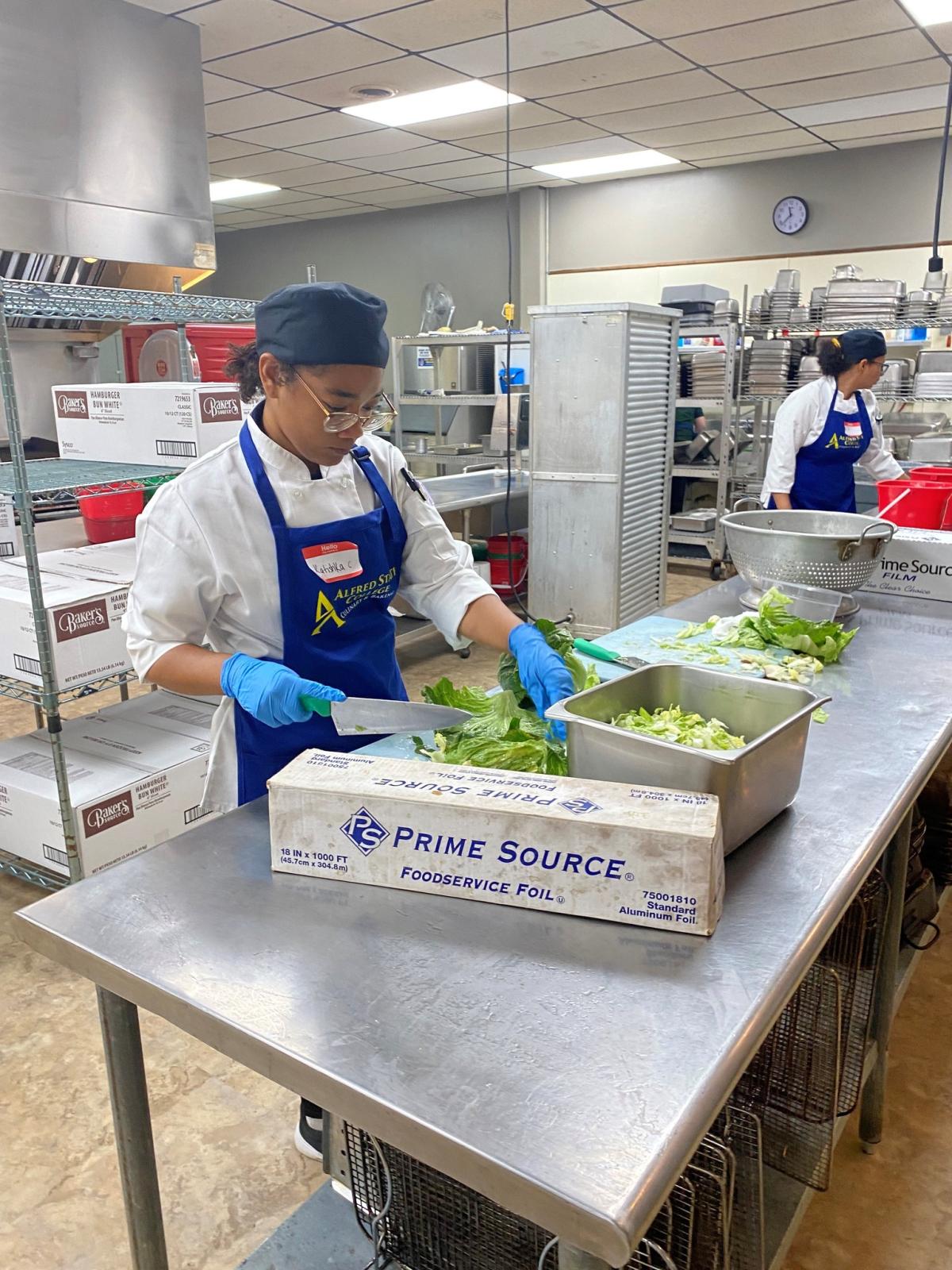 An Alfred State student prepares a meal in a kitchen