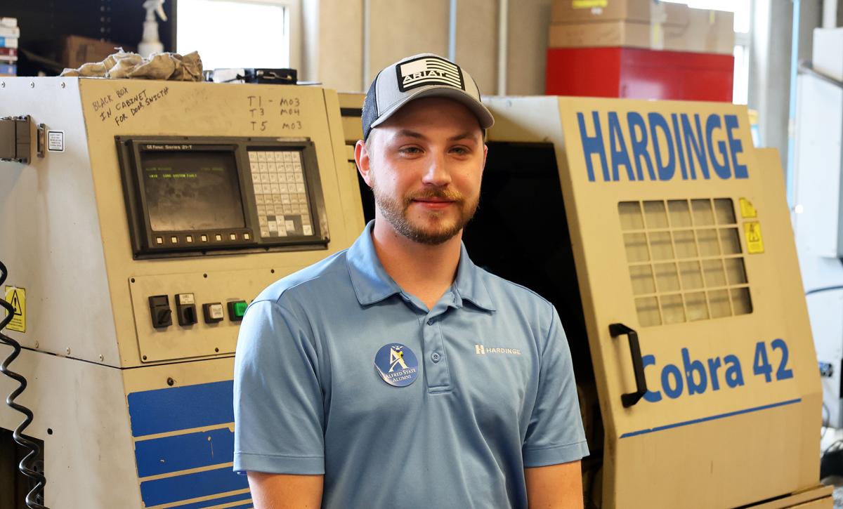 Student stands in front of machinery
