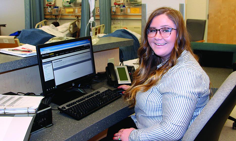 student sitting at a computer in a healthcare facility