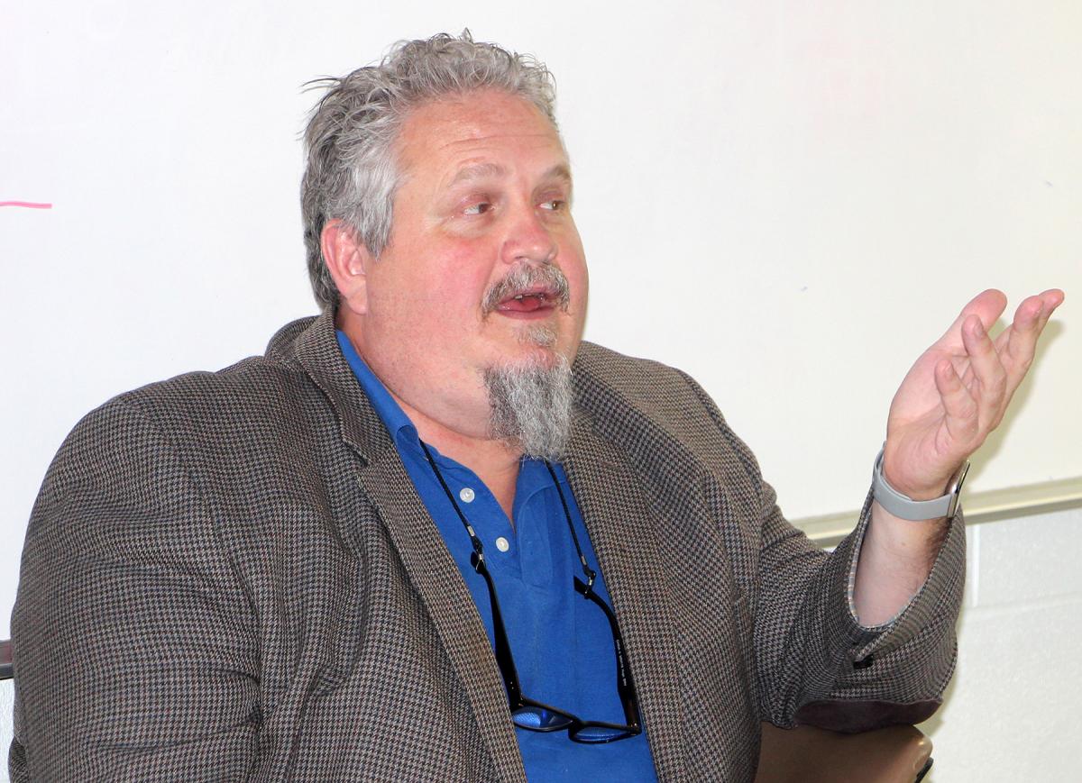 Evan Enke speaks to his students in the classroom.