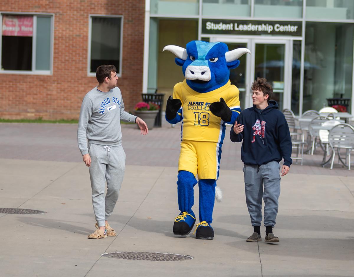 Big Blue walks to class with a pair of Alfred State College students. 