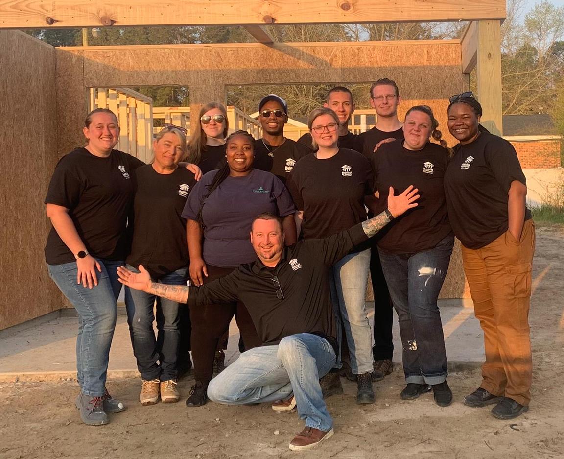 Students pose at the worksite of a Habitat for Humanity house