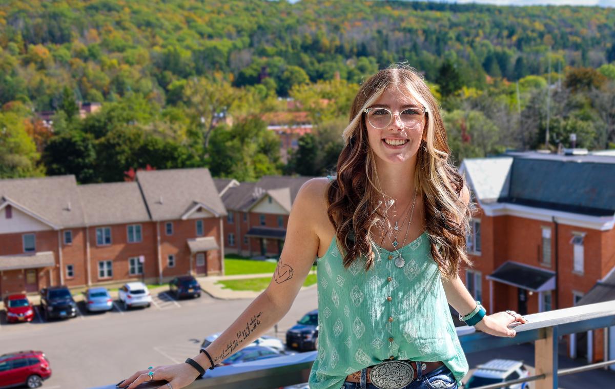 student standing on a balcony overlooking the valley