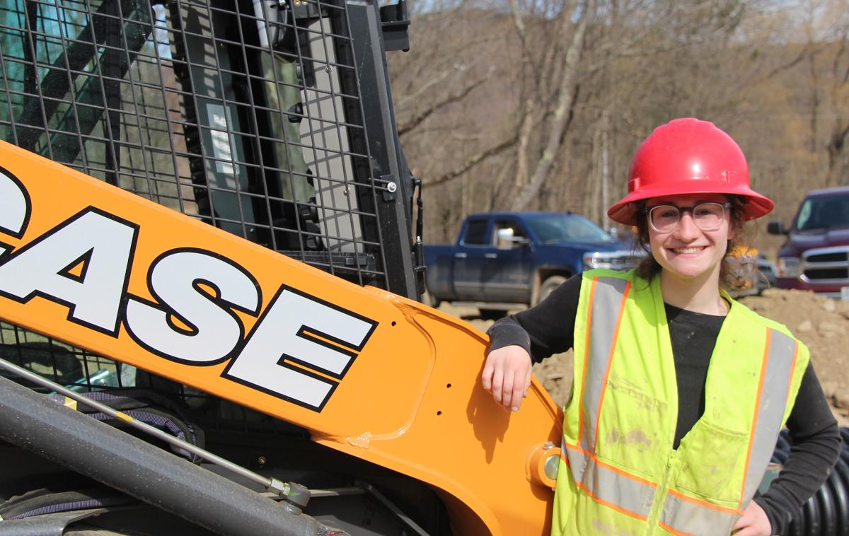 student stands near heavy equipment