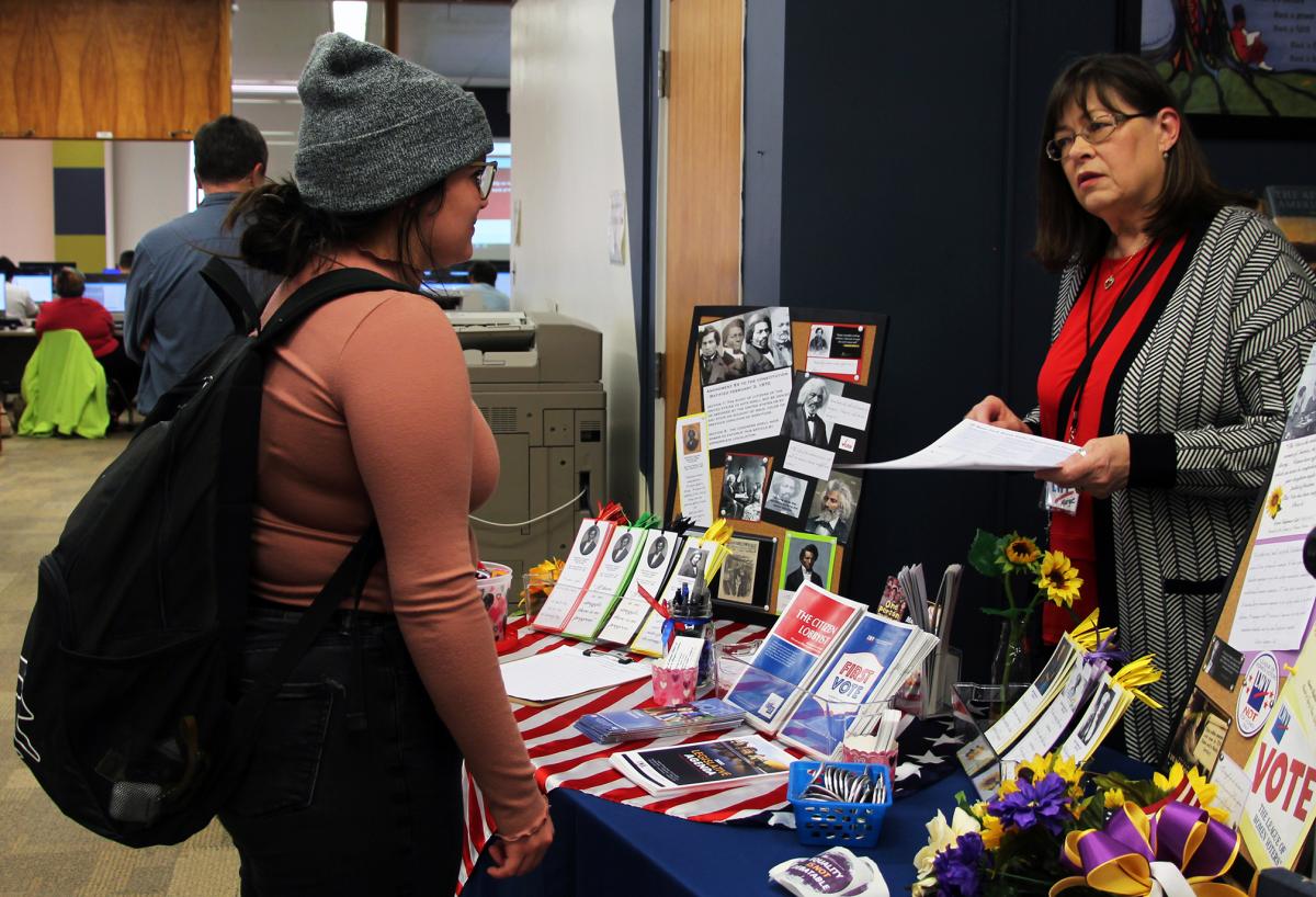 A student speaks with a League of Women Voters representative