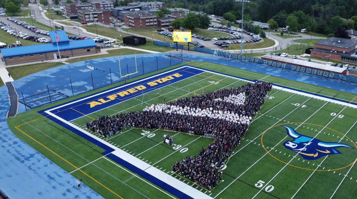   An arial photo showing students grouped together to form the ASC logo.

