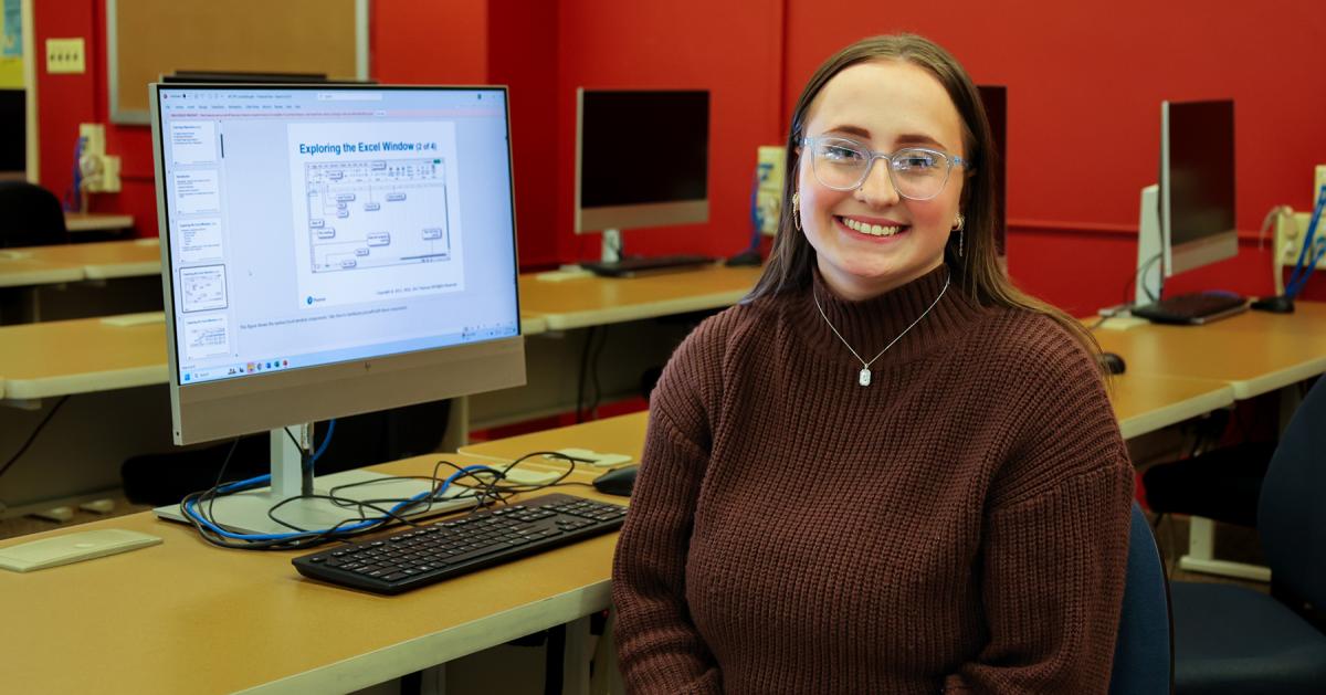 Smiling student in front of her computer