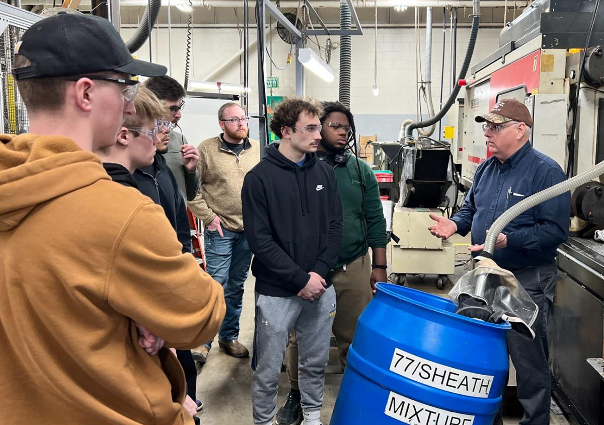 students listen to ASC alum Paul Majot during a visit to KA-Bar
