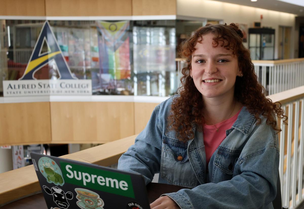 student smiling while she works on computer