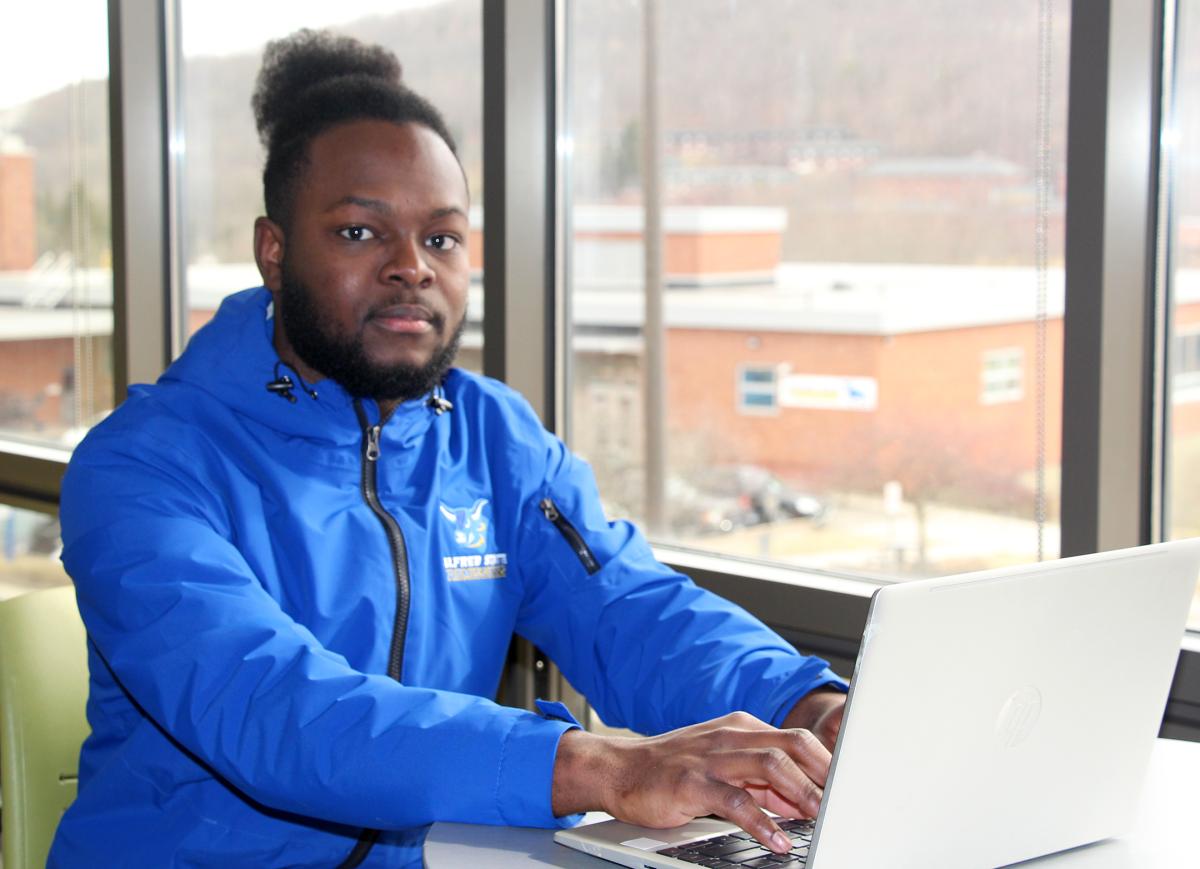 students sitting behind a laptop in a dorm lounge