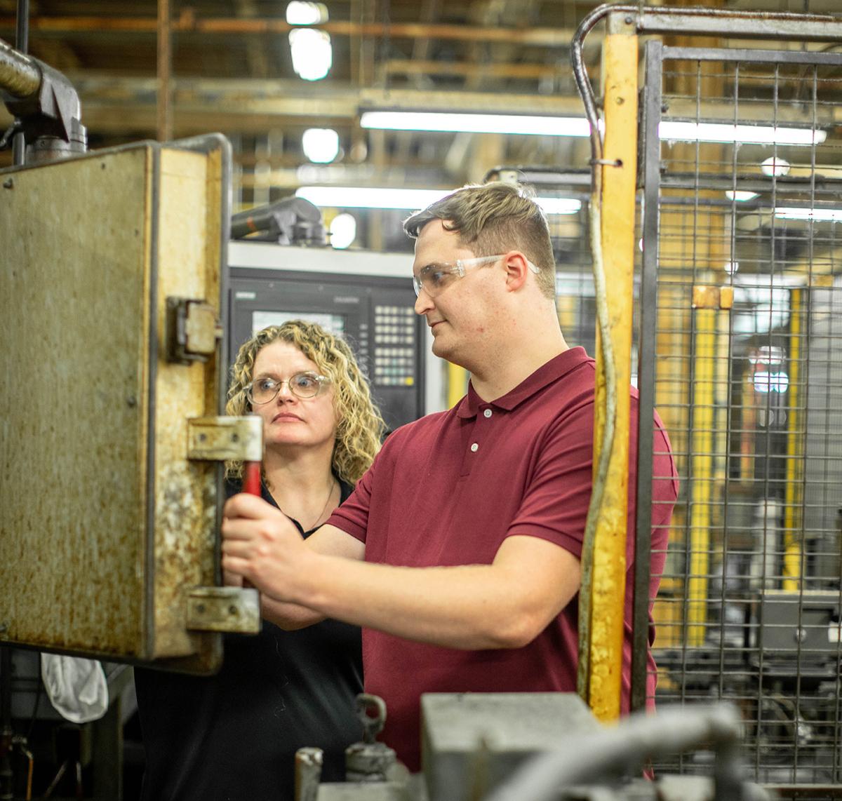 A student and an instructor work in a lab