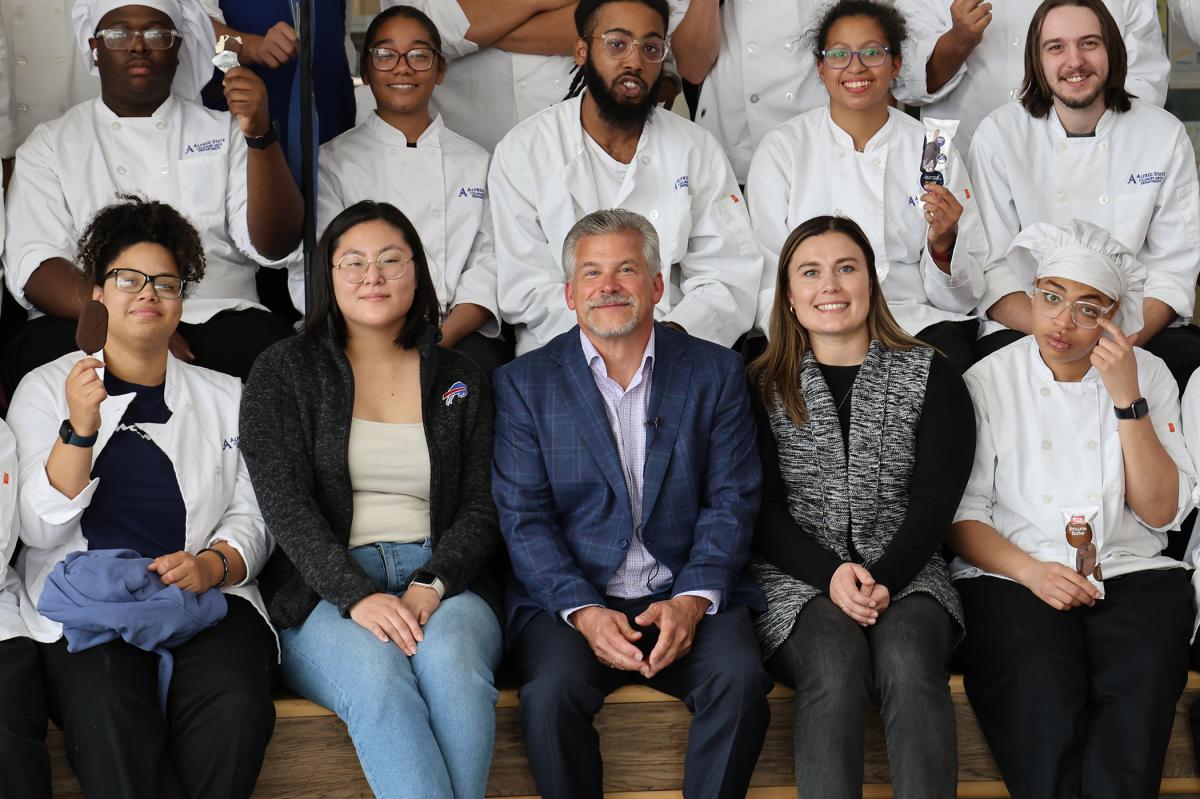 Students pose with an alum
