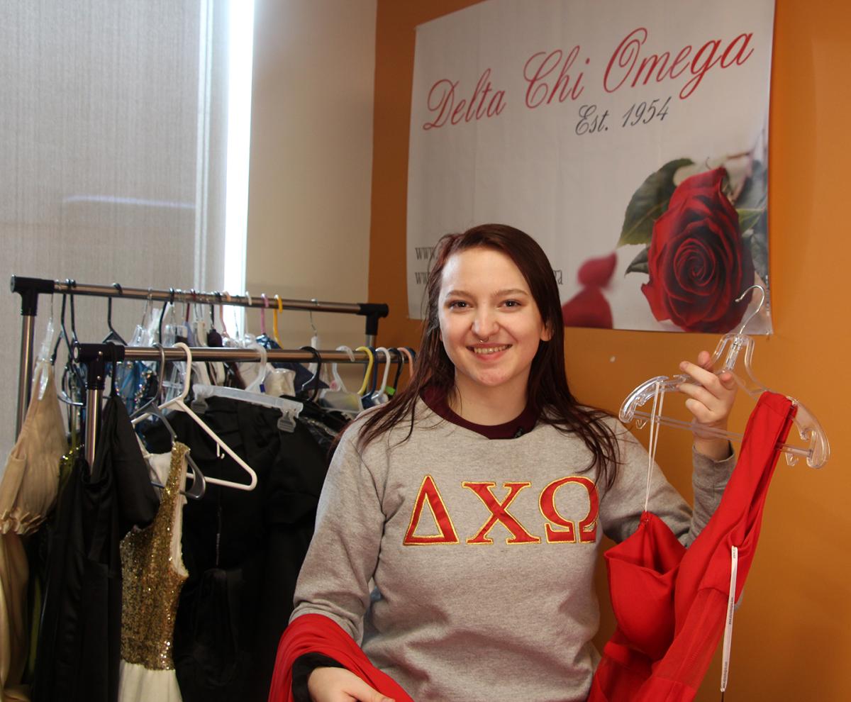 Delta Chi Omega sister Jenna Plouse shows off one of the dresses that will be available at Project Prom Dress. The event will be held April 8 in the Pioneer Center.
