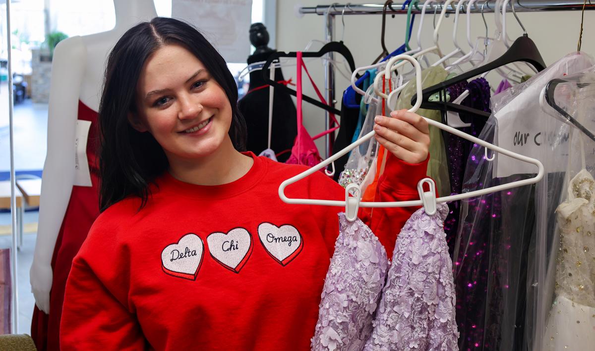 student holds a dress