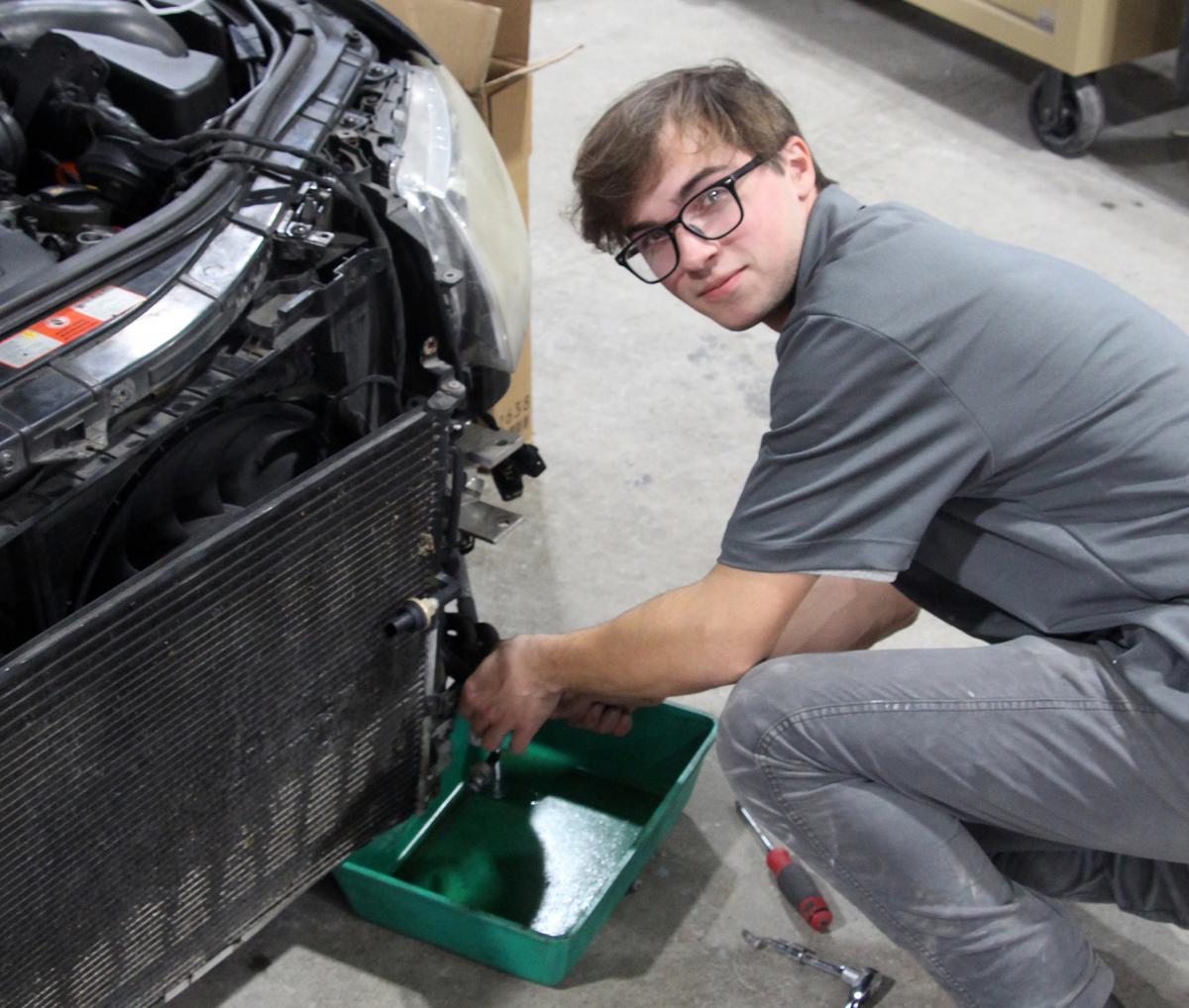 Autobody student Mikal Smith works on a wrecked car in the autobody shop at Alfred State College.