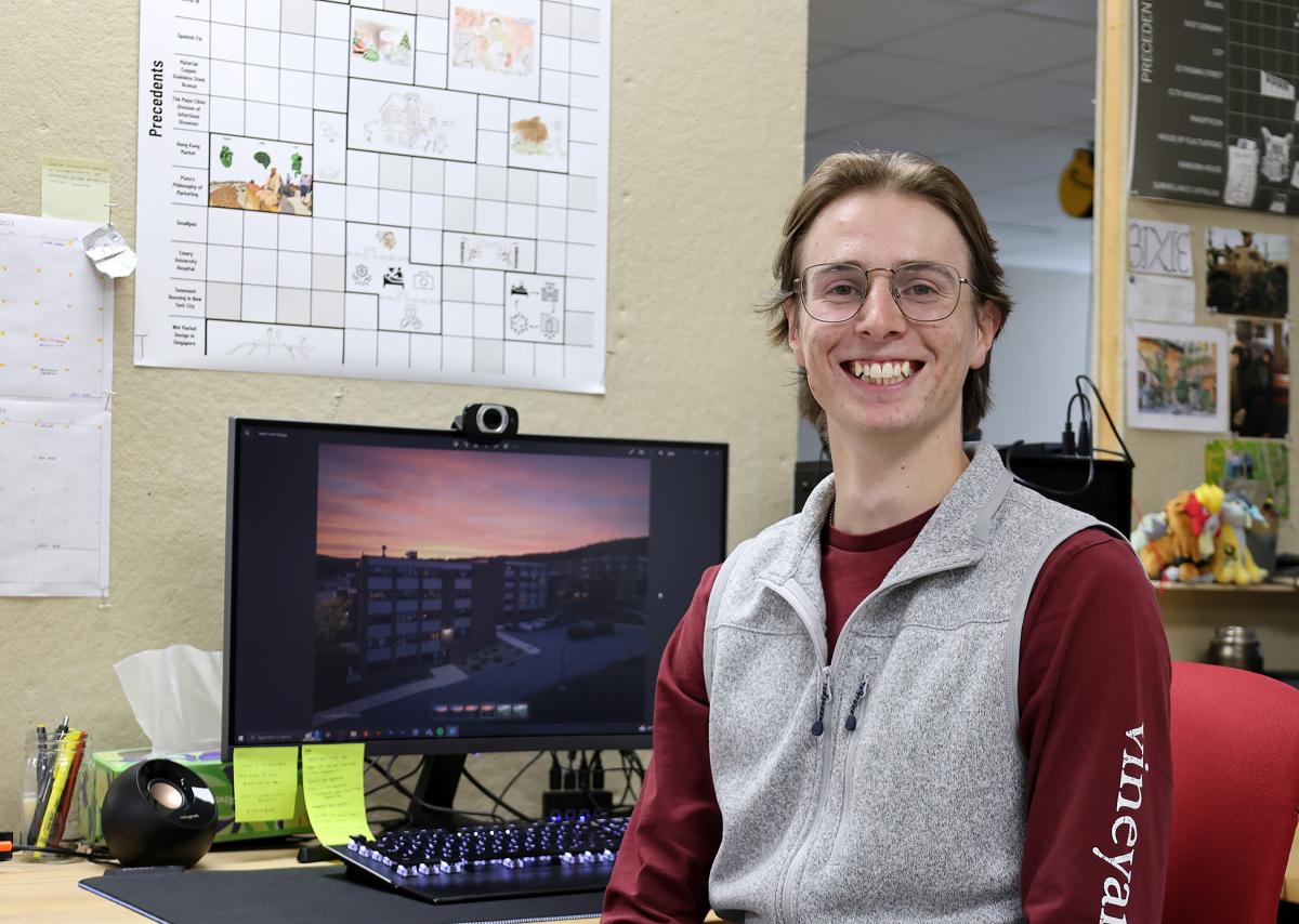 student sits at his desk in front of his architecture projects