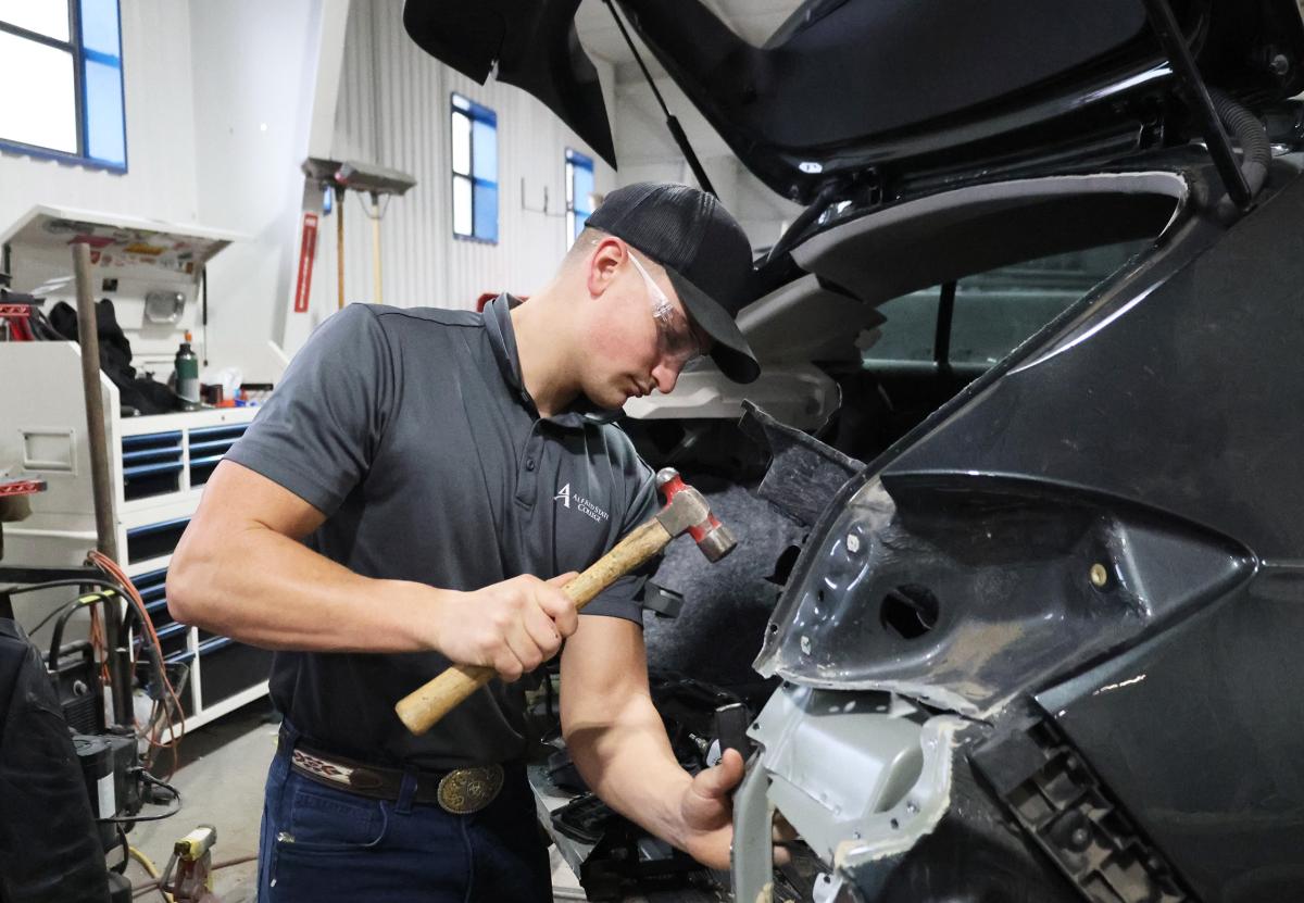 Student works on a wrecked car